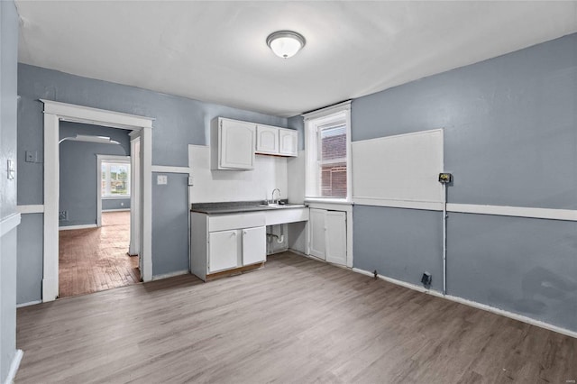 kitchen featuring sink, light hardwood / wood-style flooring, and white cabinets