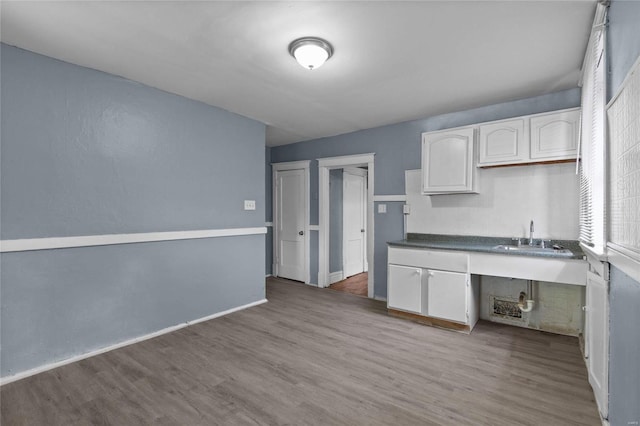 kitchen featuring white cabinetry, sink, and hardwood / wood-style floors