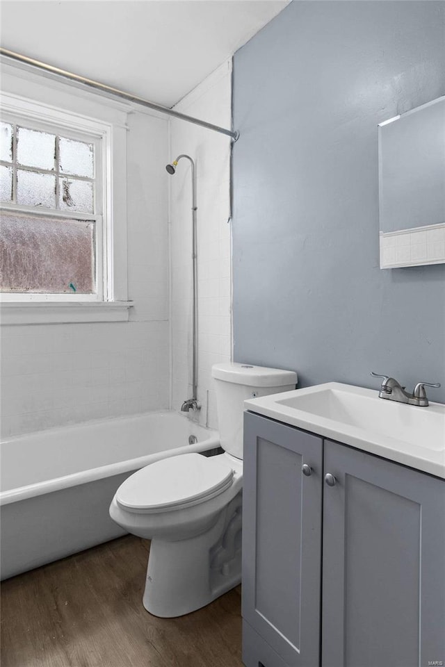 full bathroom with vanity, hardwood / wood-style flooring,  shower combination, and toilet