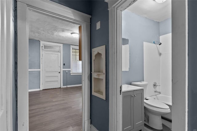 full bathroom with vanity, wood-type flooring, shower / bathtub combination, and toilet