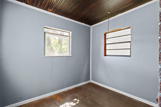 spare room with dark wood-type flooring, wood ceiling, and crown molding