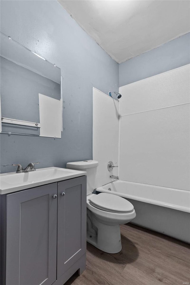 full bathroom with toilet, vanity, shower / washtub combination, and hardwood / wood-style floors