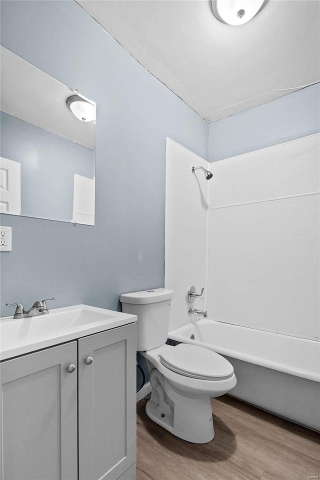 full bathroom with vanity, wood-type flooring,  shower combination, and toilet