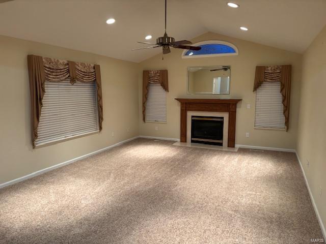 unfurnished living room with ceiling fan, carpet, and vaulted ceiling