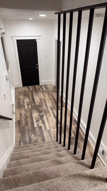 stairs featuring hardwood / wood-style floors