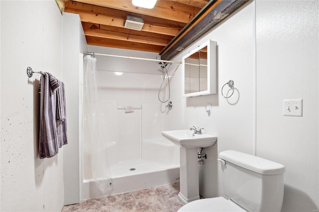 bathroom featuring curtained shower and toilet