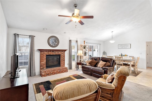 living room featuring light carpet, ceiling fan, a brick fireplace, and lofted ceiling