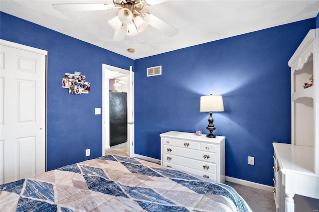 bedroom featuring visible vents, freestanding refrigerator, carpet, baseboards, and ceiling fan