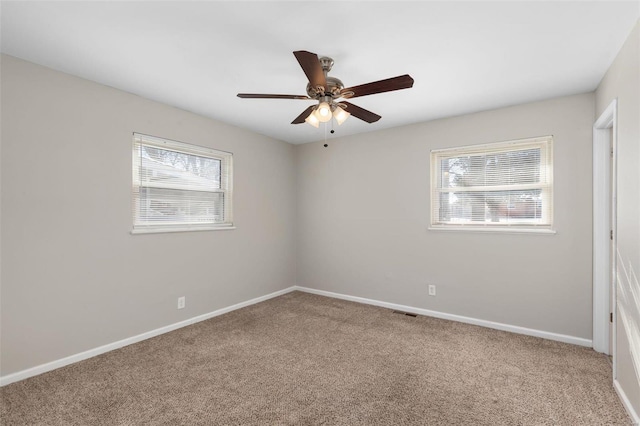 spare room with ceiling fan and carpet