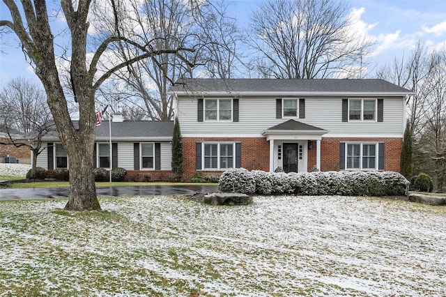 view of front of home with brick siding and a chimney