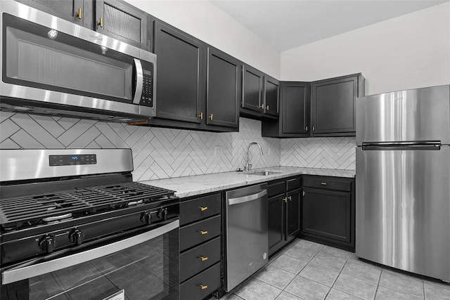 kitchen with sink, light stone counters, tasteful backsplash, light tile patterned floors, and stainless steel appliances