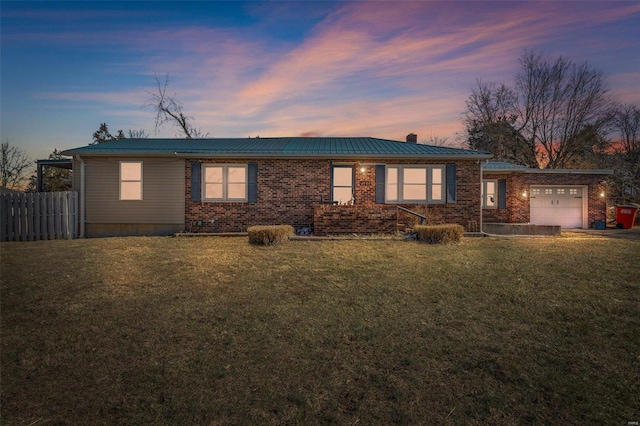 ranch-style house with a garage and a lawn