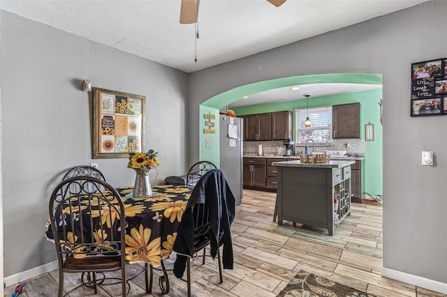 dining room with ceiling fan, sink, and a textured ceiling