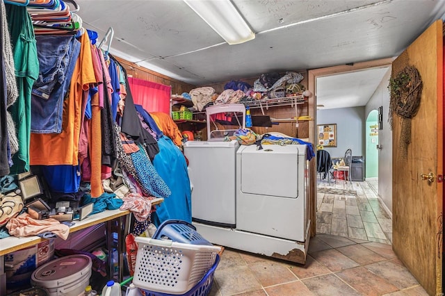 laundry room featuring independent washer and dryer and wood walls
