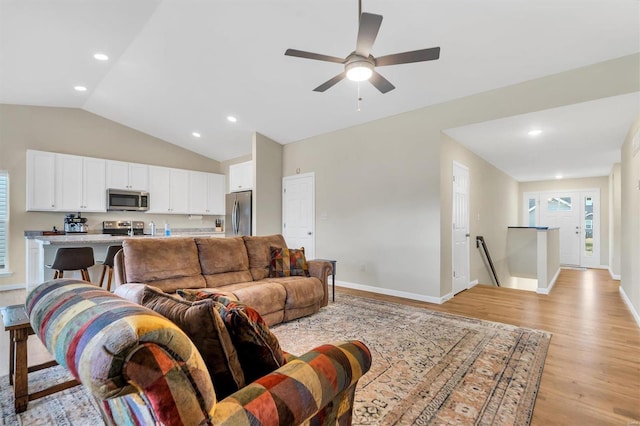 living room featuring ceiling fan, lofted ceiling, and light hardwood / wood-style floors