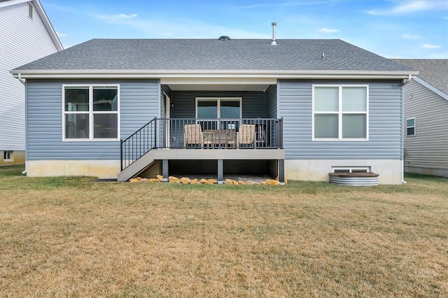 back of property featuring a wooden deck and a lawn