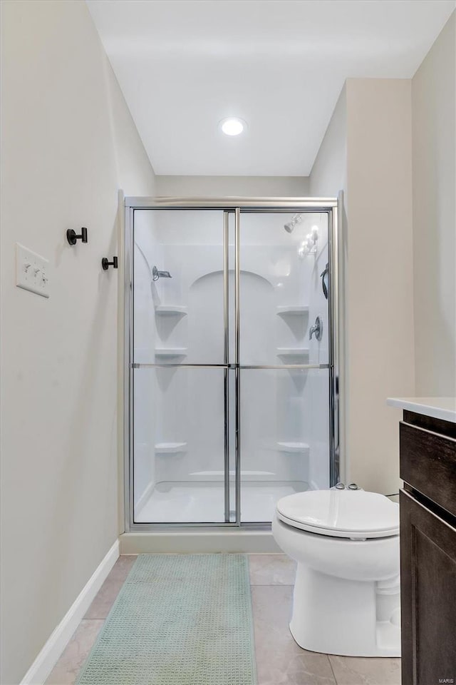 bathroom with toilet, vanity, tile patterned floors, and walk in shower