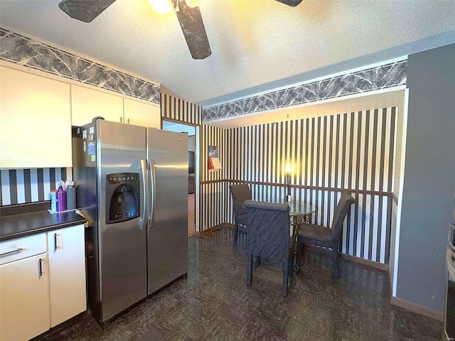 kitchen featuring stainless steel refrigerator with ice dispenser, ceiling fan, and a textured ceiling