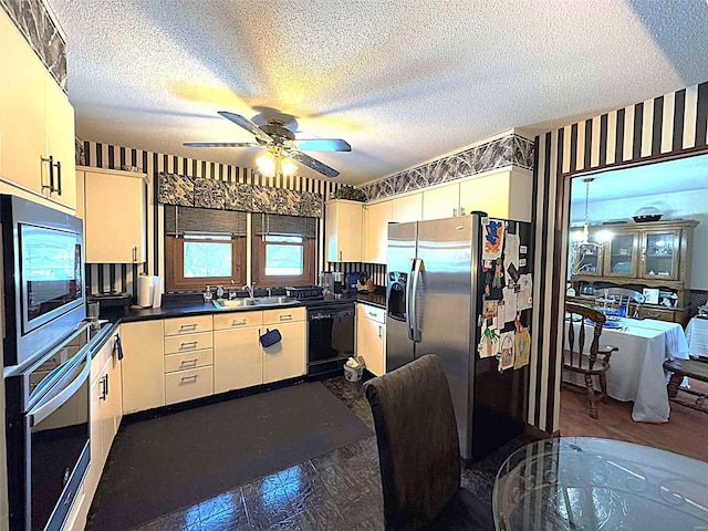 kitchen featuring stainless steel appliances, sink, a textured ceiling, and ceiling fan