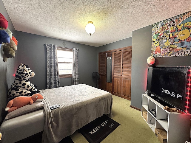 carpeted bedroom with a textured ceiling and a closet