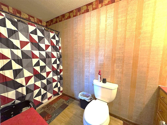 bathroom featuring a textured ceiling, toilet, and walk in shower