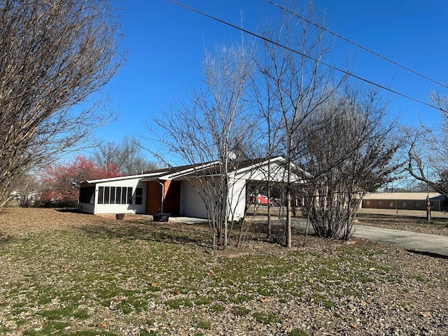 view of front of property with a carport, a front lawn, and a sunroom