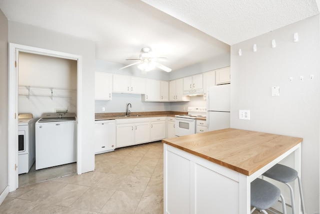 kitchen with washer and dryer, sink, white appliances, and kitchen peninsula