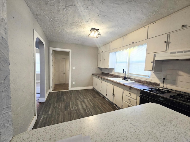 kitchen with white cabinetry, sink, dark hardwood / wood-style flooring, gas stove, and a textured ceiling