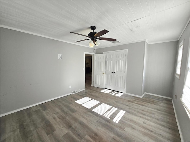 unfurnished bedroom featuring hardwood / wood-style floors, ceiling fan, crown molding, wooden ceiling, and a closet