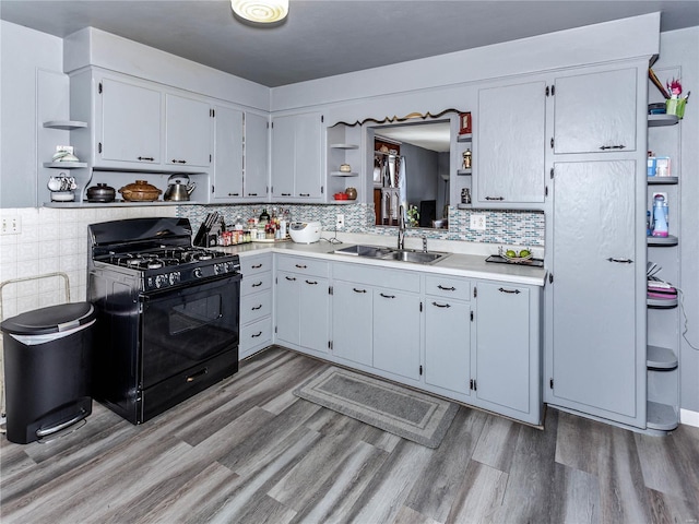 kitchen with tasteful backsplash, sink, black range with gas stovetop, and hardwood / wood-style flooring