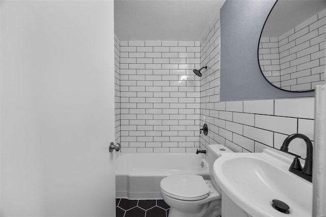 full bathroom with toilet, sink, tile walls, tiled shower / bath combo, and tile patterned flooring