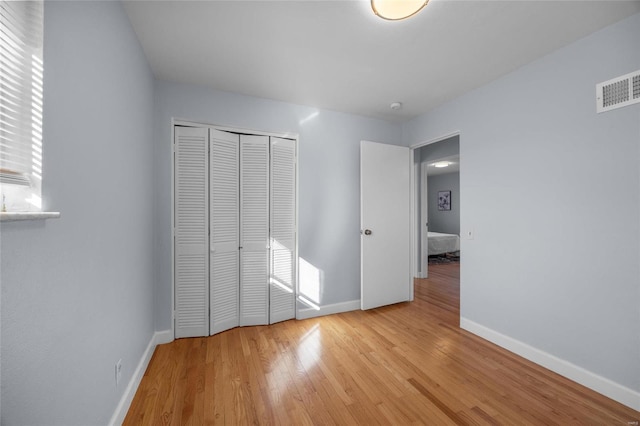 unfurnished bedroom featuring light hardwood / wood-style floors and a closet