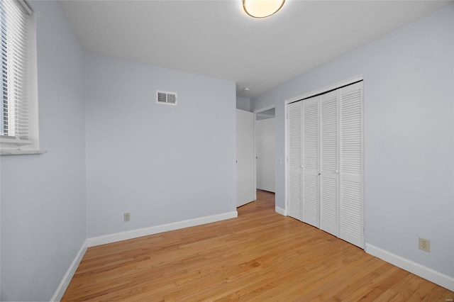 unfurnished bedroom featuring a closet and light hardwood / wood-style flooring