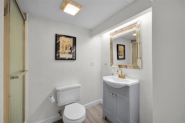 bathroom featuring vanity, hardwood / wood-style flooring, and toilet