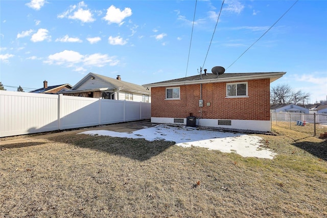 rear view of property featuring a yard and central air condition unit