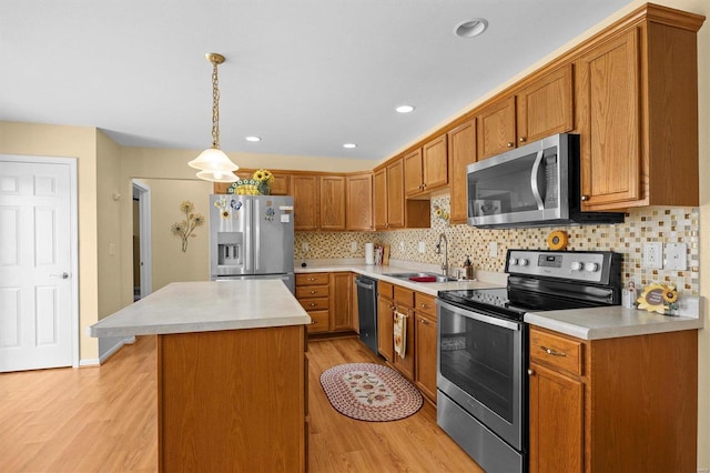 kitchen featuring sink, a center island, hanging light fixtures, appliances with stainless steel finishes, and backsplash