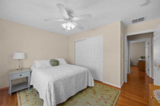 bedroom with hardwood / wood-style floors, ceiling fan, and a closet