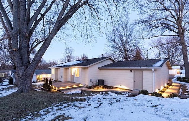 snow covered house featuring a wooden deck and central AC unit