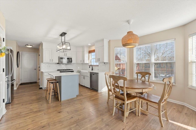 dining area featuring sink and light wood-type flooring