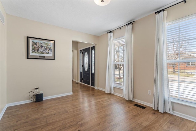 entryway with hardwood / wood-style floors and a textured ceiling