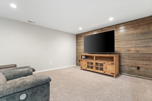 living room featuring wooden walls and light colored carpet