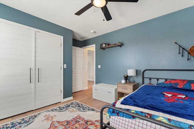 bedroom featuring a textured ceiling, light hardwood / wood-style flooring, and ceiling fan