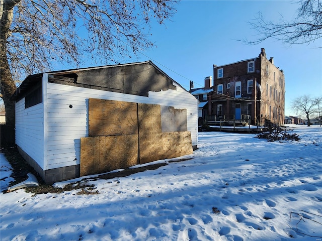 snow covered property with an outbuilding