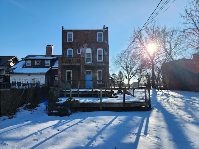 snow covered house featuring a wooden deck