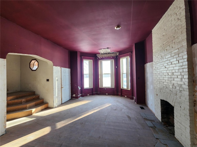 unfurnished living room featuring an outdoor brick fireplace