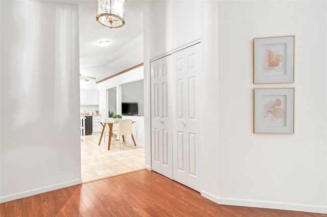 hallway with hardwood / wood-style flooring and lofted ceiling