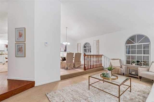 carpeted living room featuring an inviting chandelier and lofted ceiling