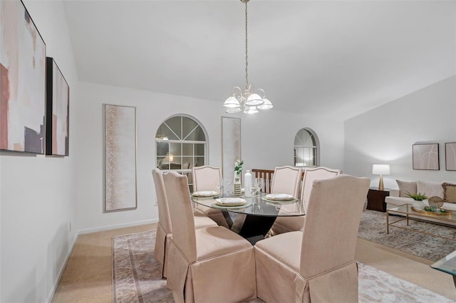 carpeted dining room featuring an inviting chandelier