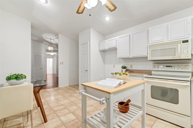 kitchen with white appliances, white cabinetry, light tile patterned floors, and hanging light fixtures