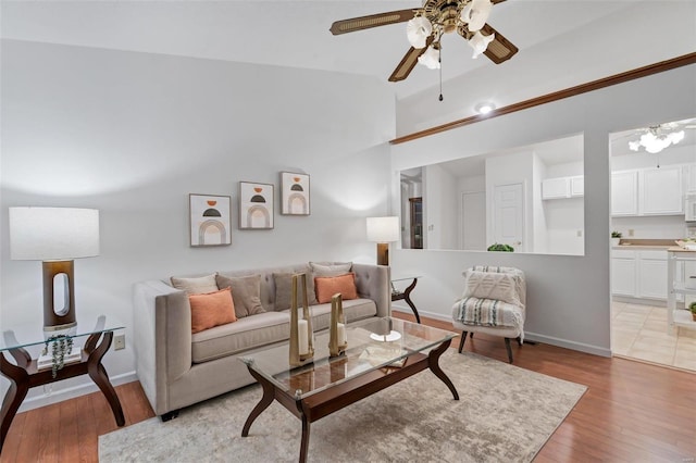 living room featuring light hardwood / wood-style floors, lofted ceiling, and ceiling fan